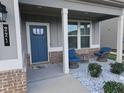 Front porch with blue door and seating area at 221 Eleanora Way, Loganville, GA 30052