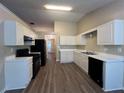 Kitchen with white cabinets, black appliances, and hardwood floors at 3510 Tiffany Se Dr, Conyers, GA 30013