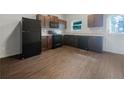Modern kitchen featuring dark wood cabinets, black appliances, and wood-look flooring at 2136 Chadwick Sw Rd, Atlanta, GA 30331