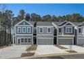 Three-unit townhome building, gray siding, two-car garages, and landscaping at 5142 Longview Run, Decatur, GA 30035