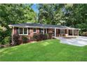 Brick ranch house with a large green lawn and mature trees at 4028 Creel Dr, Lithia Springs, GA 30122