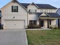 Two story home with white siding, gray roof, and a two car garage at 4430 Vernon Nw St, Lilburn, GA 30047