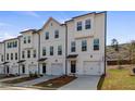 Row of three-story townhouses with white siding and attached garages at 77 Werner Brook Way, Atlanta, GA 30354
