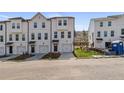 Three-story townhouses with white siding, two-car garages, and landscaping at 77 Werner Brook Way, Atlanta, GA 30354