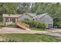 House exterior showcasing a gray siding, double garage, and carport at 5833 Wind Haven Nw Ct, Kennesaw, GA 30152