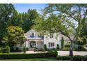 Beautiful white two-story house with lush green landscaping and a long driveway at 5091 Riverview Nw Rd, Sandy Springs, GA 30327