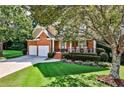 Landscaped front yard with lush green grass and mature trees at 738 Key Largo Ct, Auburn, GA 30011