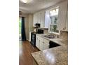 Eat-in kitchen with white cabinets and granite countertops at 1325 Smokerise Ln, Auburn, GA 30011