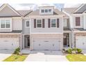 Townhouse with gray siding, brown shutters, and a two-car garage at 7745 Squire Ct, Fairburn, GA 30213