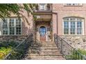 Brick front entry with stone accents, arched door, and wrought iron railings at 1829 Buckhead Valley Ne Ln, Atlanta, GA 30324