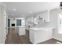 Modern white kitchen with center island, quartz countertops, and stainless steel appliances at 772 Brookwood Sw Ter, Lilburn, GA 30047