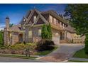 Elegant brick home with stone accents, landscaped yard, and a long driveway at 850 Camden Park Ct, Atlanta, GA 30342