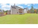 Two-story house with brick facade, large deck, and expansive lawn at 4847 Basingstoke Dr, Suwanee, GA 30024