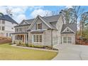 Two story house with gray brick, metal roof, and landscaping at 4847 Basingstoke Dr, Suwanee, GA 30024