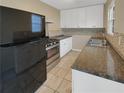 Modern kitchen with black appliances and granite countertops at 707 Pine Tree Trl # 10B, Atlanta, GA 30349