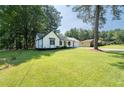 White ranch home with a large green lawn and mature trees at 10100 Clearview Nw Dr, Covington, GA 30014