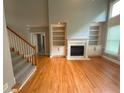 Spacious living room with hardwood floors, fireplace, built-in shelving, and high ceilings at 617 Vinings Estates Se Dr, Mableton, GA 30126