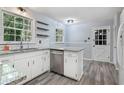 Updated kitchen with white cabinets, granite counters, and wood floors at 873 Hearthstone Dr, Stone Mountain, GA 30083