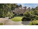 Brick Georgian style home with manicured lawn and circular driveway at 3560 Ridgewood Nw Rd, Atlanta, GA 30327