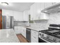 Renovated kitchen with white shaker cabinets, granite countertops, and stainless steel appliances at 4440 Stonewall Tell Rd, Atlanta, GA 30349
