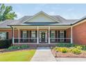 Brick house with a covered porch, black shutters, and a manicured lawn at 12 Ivy Chase Nw Way, Cartersville, GA 30121