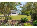 Landscaped backyard with a bench, lush greenery, and a view of the house and garage at 12 Ivy Chase Nw Way, Cartersville, GA 30121