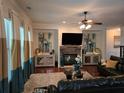 Spacious living room featuring a stone fireplace and large TV at 6856 Louis Dr, Locust Grove, GA 30248