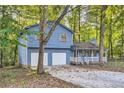 Two-story light blue house with attached two-car garage at 34 Powder Brook Ct, Dallas, GA 30157