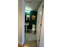 Stylish powder room with pedestal sink, toilet and green walls at 563 Se Memorial Se Dr # 401, Atlanta, GA 30312