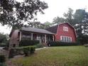Red barn-style home with a large yard and driveway at 3090 Trickum Rd, Marietta, GA 30066