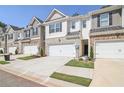 Row of townhouses with attached garages and landscaping at 174 Hampton Cir, Mcdonough, GA 30253