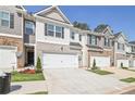 Row of townhouses with attached garages and landscaping at 174 Hampton Cir, Mcdonough, GA 30253
