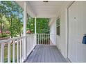 Inviting front porch with white railings, gray floor, and lush green trees in the background at 5163 Lakeside Dr, Dunwoody, GA 30360