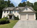 Two-story house with beige siding, two-car garage, and landscaping at 906 Fox Croft Pl, Canton, GA 30114