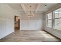 Bright dining room features a chandelier, hardwood floors, and decorative wall paneling at 25 Homesite Cooper E Cv, Fayetteville, GA 30215
