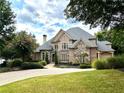 Brick home with stone accents, large driveway, and manicured lawn at 2867 Darlington Run, Duluth, GA 30097