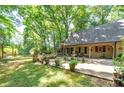 Spacious backyard with patio, lush landscaping, and mature trees at 3154 Highway 155 N, Mcdonough, GA 30252