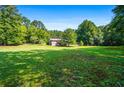 Large backyard with green lawn, providing privacy at 725 Holland Rd, Powder Springs, GA 30127