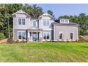 Two story gray house with white accents and green lawn at 200 Etris Grove Ct, Roswell, GA 30075