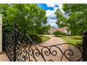 Ornate gate opening to a mansion with a long driveway at 1005 Oak Mountain Rd, Carrollton, GA 30116