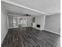 Living room with gray walls, gray wood-look tile floors and a fireplace at 6493 Crooked Creek Pl, Lithonia, GA 30058