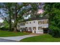 Front exterior of a white, two-story house with a driveway, front yard, and attached garage at dusk at 3840 Wieuca Ne Ter, Atlanta, GA 30342