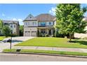 Two-story house with brick facade, three-car garage, and landscaped lawn at 4550 Fernbrook Pl, Cumming, GA 30040
