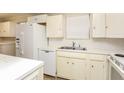 Kitchen with white cabinets, appliances, and a double sink at 2072 Clairmont Ter, Atlanta, GA 30345