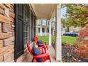 Relaxing front porch with two red adirondack chairs and pillows at 410 Azalea Cv, Canton, GA 30114