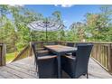 Wooden deck with outdoor dining set and striped umbrella at 10 Argyll Way, Covington, GA 30014