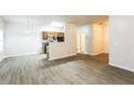 Open living space with hardwood floors, kitchen access, and neutral colors at 6393 Shadow Sq, Lithonia, GA 30058