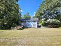 Two-story light blue house on a large lot with mature trees at 2598 Canon Sw Dr, Marietta, GA 30064