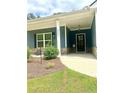 Inviting front porch with stone accents and a dark-colored front door at 8325 Loch Lomand Ln, Winston, GA 30187