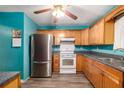 Kitchen with teal walls, wood cabinets, and stainless steel appliances at 315 Watts Rd, Hiram, GA 30141